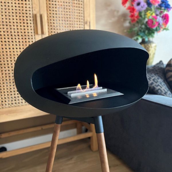 Sfeer en gezelligheid met de zwarte bioethanol haard van Enjoyfires, hij staat op 3 teakhouten poten